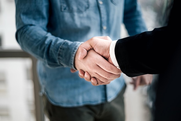 Close up shot of business handshake businessman entrepreneur freelancer shaking hands in celebration of new deal project startup company making dreams come true