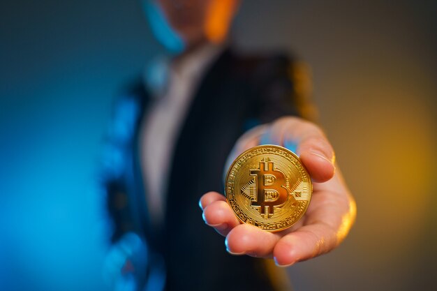 Close up shot of Business woman in black suit holding golden coin isolated on background.