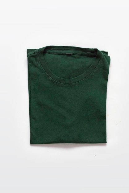 Крупный план сложенной темно-зеленой футболки на белом фоне