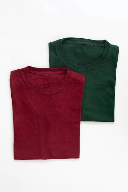 흰색 배경이 있는 접힌 짙은 빨간색과 녹색 티셔츠의 클로즈업 샷