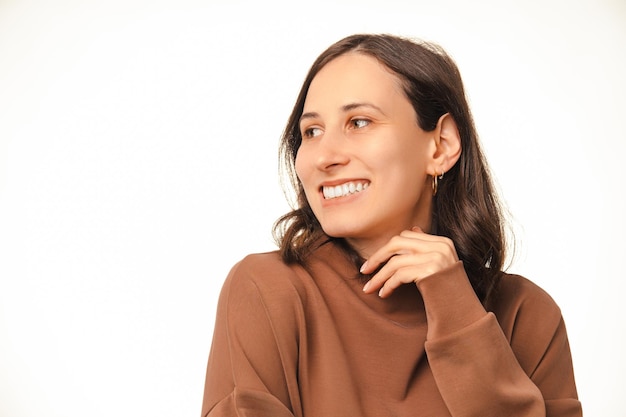 Close up shot of a gorgeous woman touching gentle her chin and looking aside