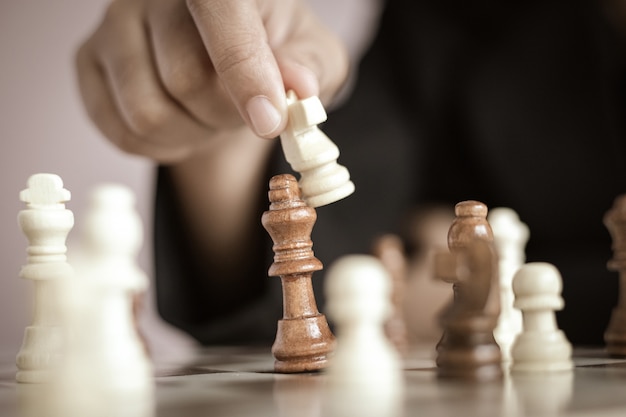 Close up shot hand of business woman playing the chess board select focus shallow depth of field