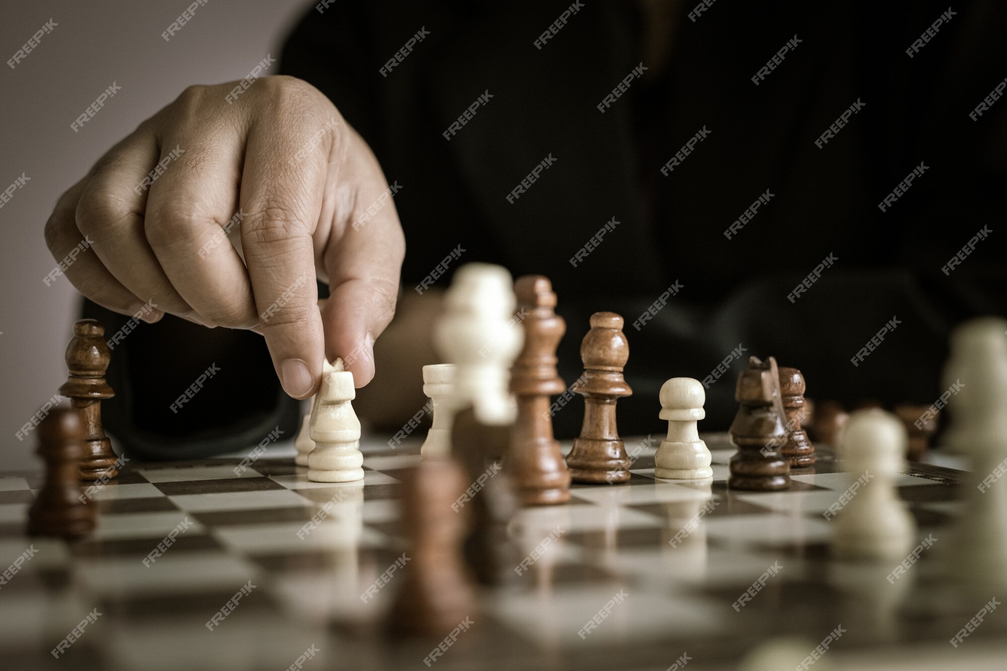 A skilled hand deftly slides a chess piece marked Chess across