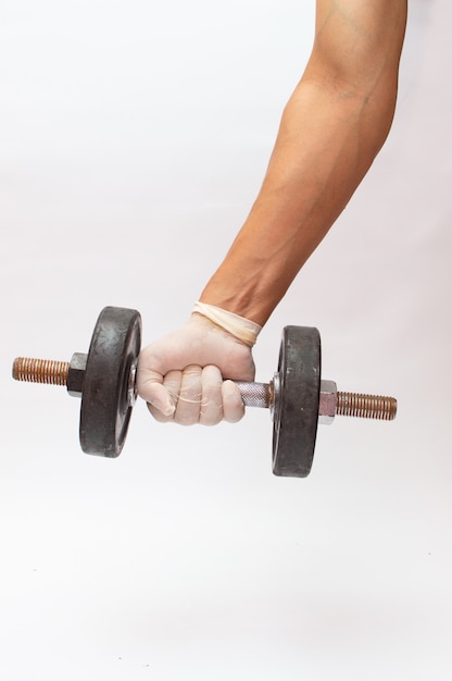 Close up shot of a hand in medical glove holding a weight
lifting tool during covid-19 pandemic