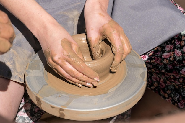 陶芸のレッスン中に粘土のボウルを作る手の接写