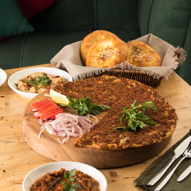 Close up shot of a lahmacun and a salad near basket of breads