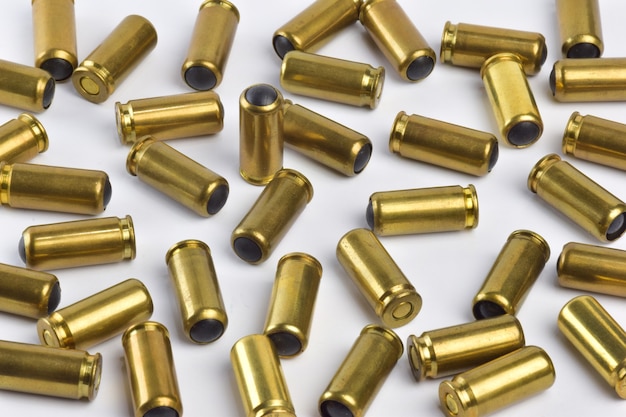 Close-up shot of a lot of bullets scattered all over the frame on a white clipping background