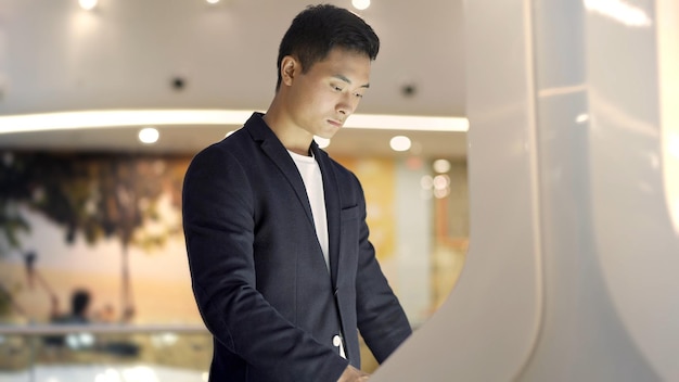 Close up shot of male hand in jacket swiping in interactive wayfinding kiosk