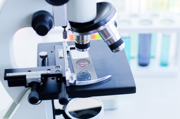 Close-up shot of microscope with metal lens at laboratory. Scientific and healthcare research background.