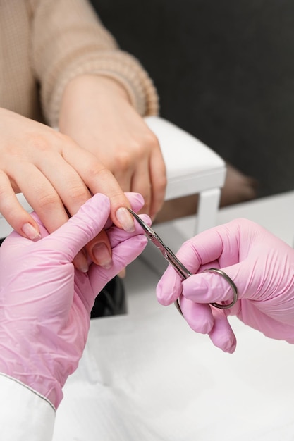 Close up shot of a nail technitian cutting the cuticle with scissors