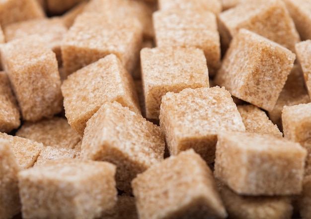 Close-Up shot of natural brown sugar cubes on white.