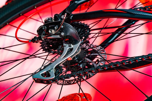 Close-up shot of new bicycle rear derailleur in red artificial lightning