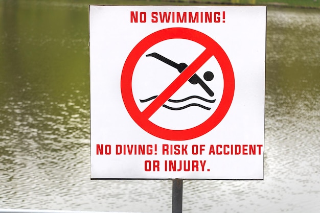 Close up shot of No Swimming sign with a pond background