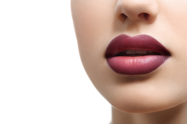 Close up shot of plump sexy female lips covered with lipstick