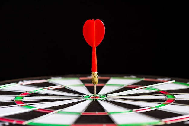 Close up shot red darts arrows in the target center on black background