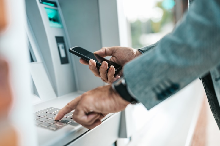 Photo close up shot of senior man hand. he typing pin code on keypad of atm machine.