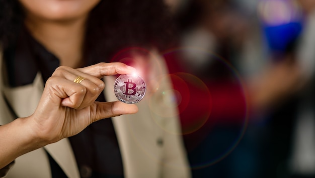 Close up shot of silver bitcoin cryptocurrency virtual token coin in professional  businesswoman