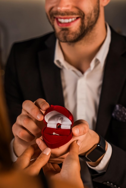 Close up shot of smiling man asking hand of his girlfriend with an engagement ring