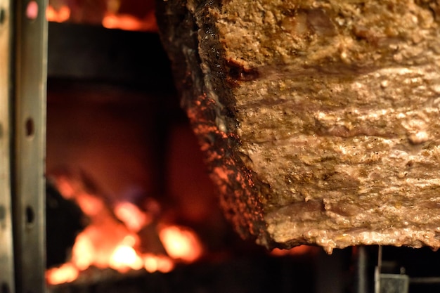 Photo close up shot of stacked meat roasting to be used in preparation of traditional greek dish gyros or turkish durum doner shawarma