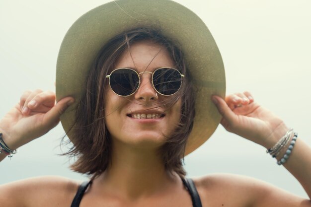 笑顔のサングラスでスタイリッシュな白人の若い女性のクローズアップショット