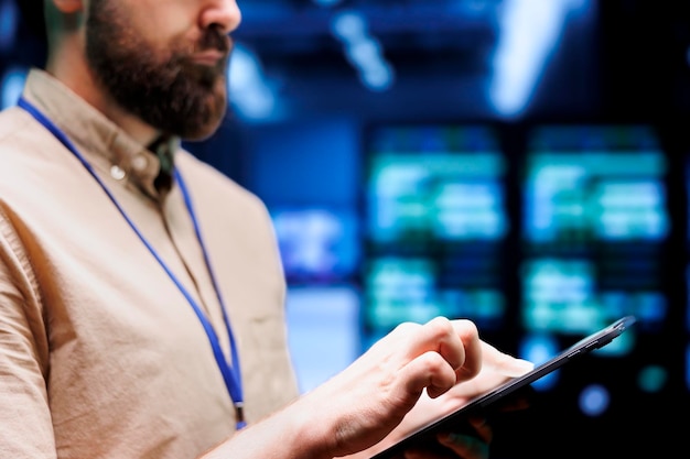 Close up shot of system administrator using tablet to check high tech establishment security features protecting against unauthorized access, data breach, ddos attacks and other cybersecurity dangers