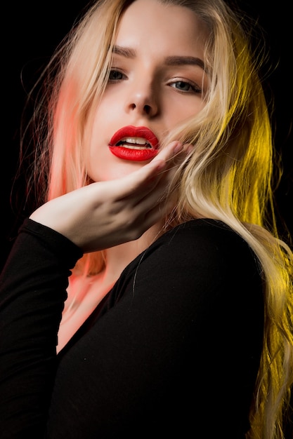 Close-up shot van aantrekkelijk blond model met professionele make-up poseren met kleurrijk licht