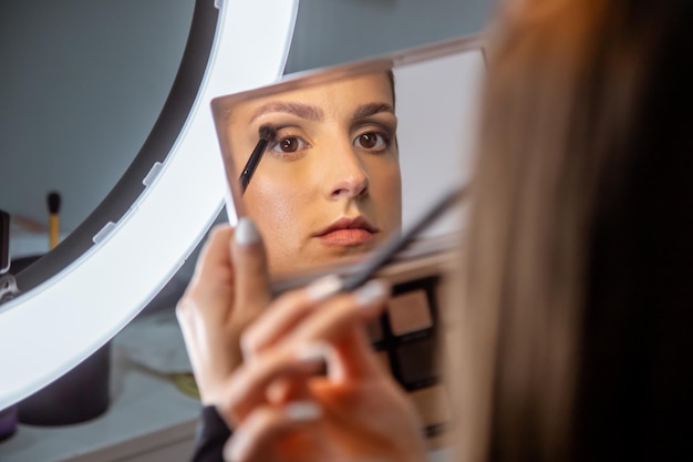 Close-up shot van een jonge blanke vrouw die make-up doet