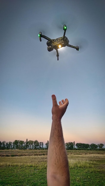 Close-up shot van een man die een drone in de lucht grijpt. Rechtopstaande foto