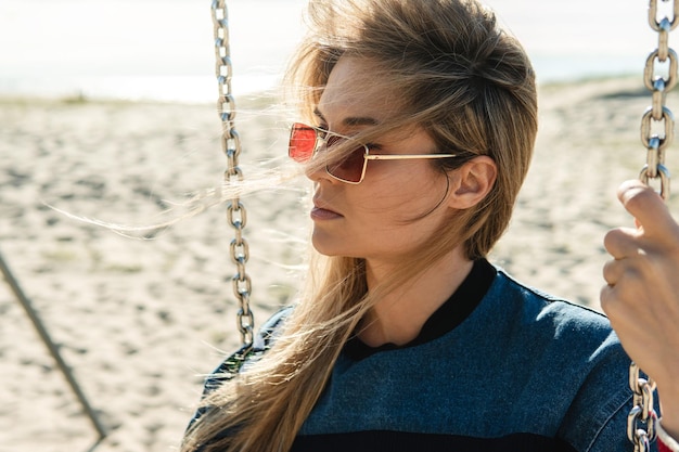 Close-up shot van jonge vrouw zittend op de schommel op het strand