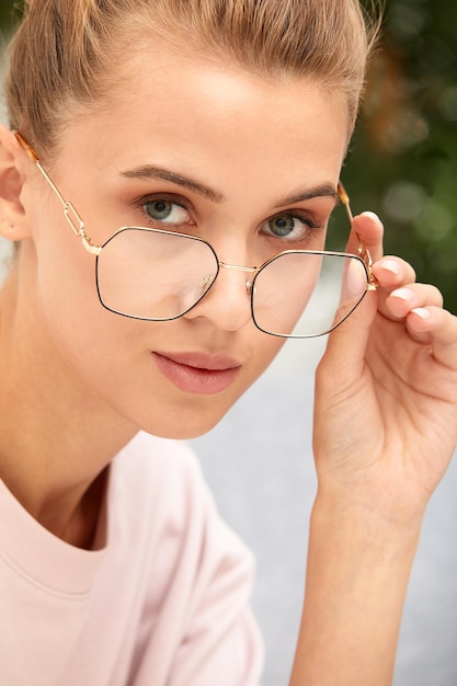 Close-up shot van lachende aantrekkelijke gelukkig en succesvolle Europese blonde vrouw in trui horloge en bril grijnzend uiten van vertrouwen op zoek naar de camera met brutale glimlach