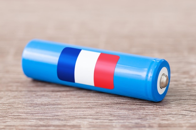 Close-up shot van liion batterij op houten tafel met vlag van Frankrijk op zijn kant Concept van het produceren van batterijen in Frankrijk oorsprong van batterijen