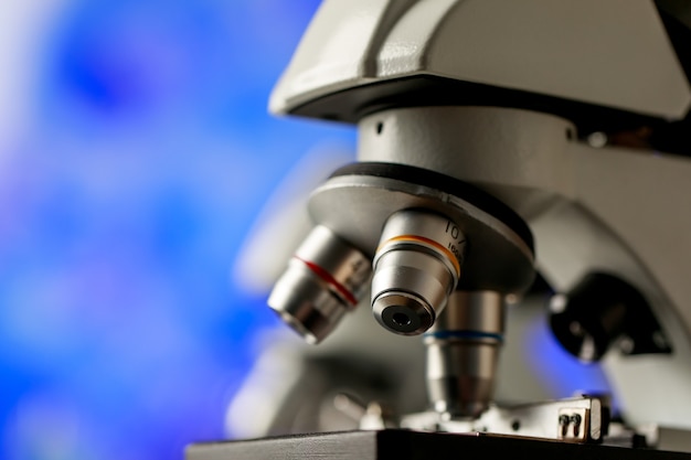 Close-up shot van microscoop met selectieve lensdoelstellingen voor verschillende vergrotings- of observatieschalen die worden gebruikt als apparaat in microbiologisch laboratorium voor onderzoek naar fysische substanties en celstudie.