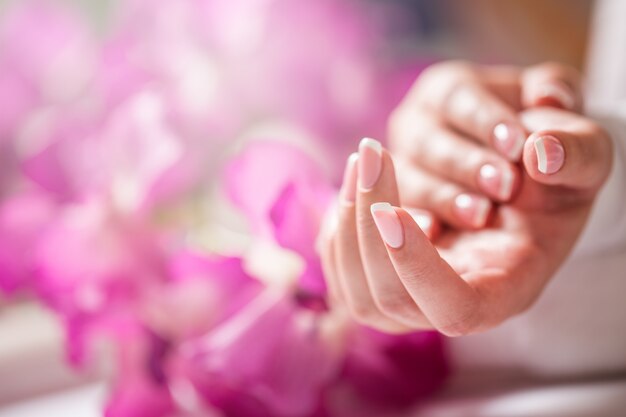 Foto close-up shot van mooie vrouwelijke dands met nagels van frankrijk manicure. manicure en spa-concept.