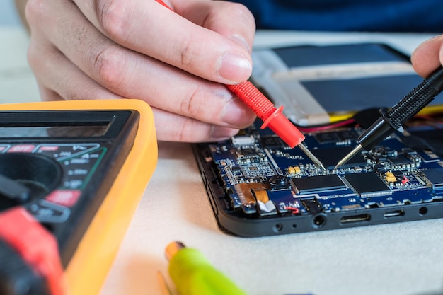 Close-up shot van reparatie van smartphones en tablets in een technologielab.