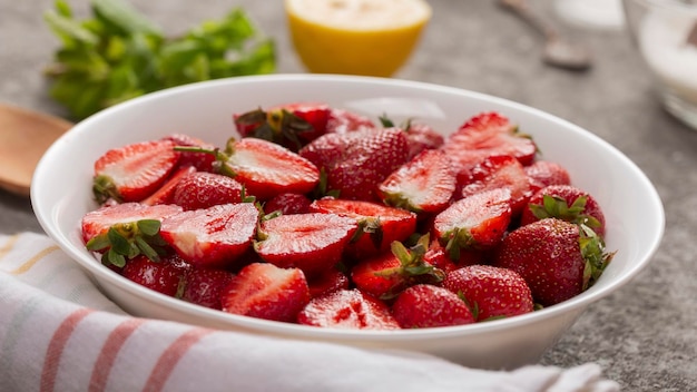 Close-up shot van rijpe gesneden aardbeien in witte plaat op tafel