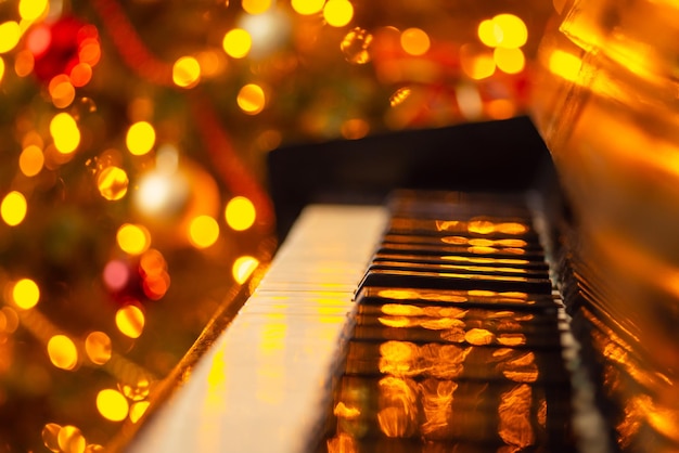 Close-up shot van toetsenbord van piano met felle lichten van slingers op de achtergrond Kerstthema-decoraties thuis