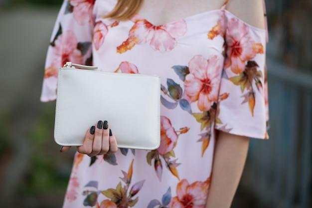 Close-up shot van vrouwelijke hand met witte lederen tas. ruimte voor tekst