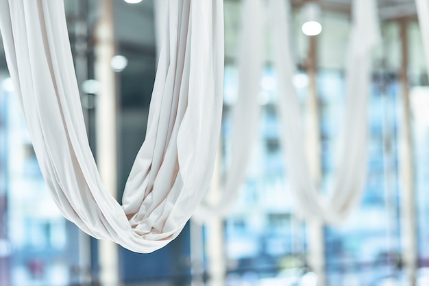 Close up shot of a white hammock for fly yoga in beautiful empty studio or