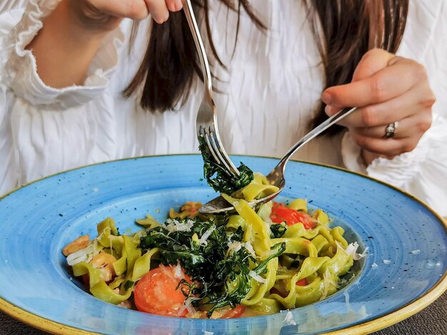 イタリアンレストランでパスタを食べている女性のクローズアップショット