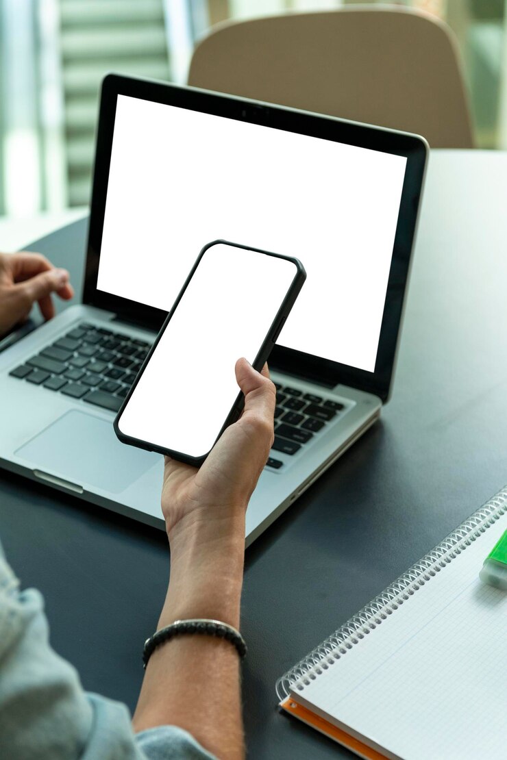 Close up shot of woman using smart phone and a laptop