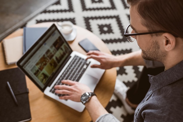 Close-up shot of young man working with laptop