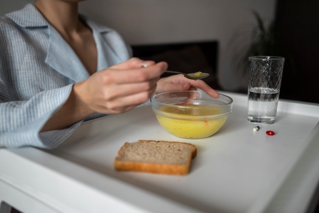 写真 スープを食べる病気の女性をクローズアップ