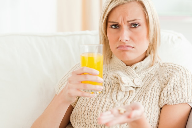 Close up of a sick woman showing pills