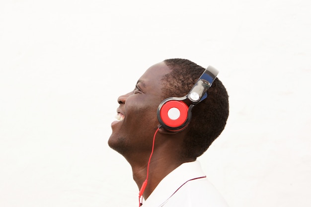 Close up side portrait of smiling man listening to music with headphones 