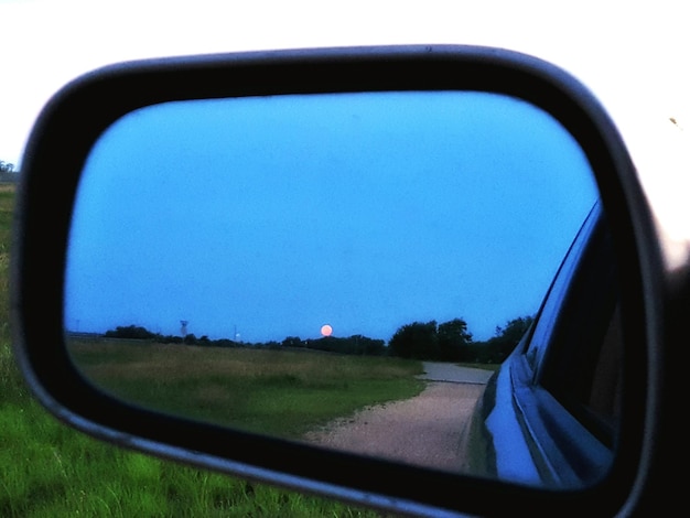 Photo close-up of side-view mirror of car