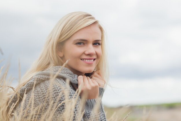 Close up side view portrait of a cute smiling young woman lying at beach