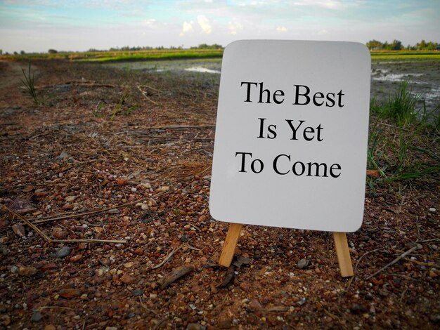 Photo close-up of sign board on field against sky