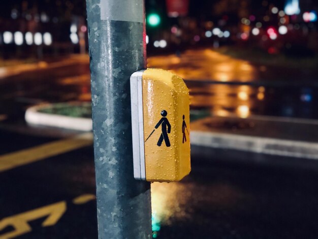 Photo close-up of sign on pole in city at night