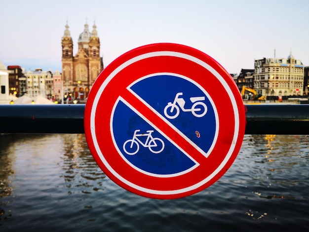 Close-up of sign on river against sky