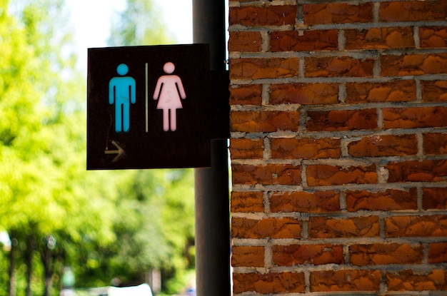 Photo close-up of signboard against brick wall